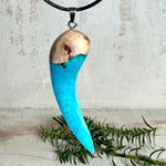 Handgefertigter Anhänger aus Edelholz und transparent-türkisblauem und weißen Epoxidharz, glatt poliert. Größe ca. 6,5 × 2,0 cm. Mit Edelstahlöse an schwarzer Lederkette (45 cm + 5 cm Edelstahl-Verlängerung, Karabiner). Moderner, unisex tragbarer Schmuck mit natürlicher Holzmaserung; kleine Lufteinschlüsse sind charakteristisch.