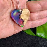 Handgefertigter Herzanhänger aus Maserholz und schimmerndem Opalharz, inspiriert von den Farben der Aurora Borealis. Das Holz zeigt eine feine Maserung, das Harz leuchtet in Rosa-, Blau- und Violetttönen. Mit zarter 925 Silber-Ankerkette (1 mm stark, 45 cm lang) und Silberöse. Ein edles Unikat in liebevoller Handarbeit gefertigt.