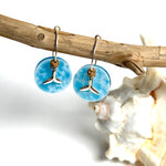 Handgefertigte Creolen-Ohrringe mit hellblauer Resin-Scheibe, zarter Wolkenmarmorierung, silbernem Walflosse-Charm und Jaspis-Natursteinperle. 925 Silber Creole, Gesamtlänge ca. 3,5 cm – Ocean-Feeling für jeden Tag.
