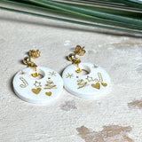 Handgefertigte Ohrringe aus weißem und klarem Harz mit goldenen Weihnachtsmotiven – Sterne, Herzen, Tannenbaum und Zuckerstange. Ohrstecker aus 925 Silber vergoldet, Anhängerschlaufe vergoldet. Größe ca. 37 mm × 25 mm. Leichte, elegante Festtagsohrringe mit warmem Goldglanz und winterlicher Ausstrahlung.