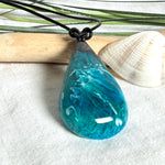Tropfen Anhänger aus dunklem Maserholz und Epoxidharz in Türkis Blau mit weißer Wellenstruktur am schwarzen Lederband, maritimer Holz Harz Naturschmuck