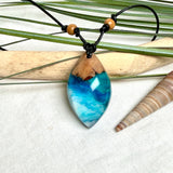 Holz-Harz-Anhänger aus Maserholz und Epoxidharz in Blau, Türkis und Weiß mit Wellenoptik am verstellbaren Lederband mit Holzperlen, handgemachter maritimer Naturschmuck