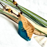Anhänger aus hellem Goldfield Maserholz (Eukalyptus) und türkis metallischem Epoxidharz am braunen Lederband mit Holzperlen, maritimer Holz Harz Naturschmuck