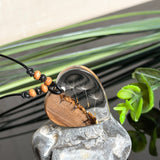 Handgefertigter Herzanhänger aus warm gemasertem Olivenholz und kristallklarem Epoxidharz mit schwebenden Pusteblumensamen. Schwarzes, verstellbares Lederband mit Schiebeknoten und naturfarbenen Holzperlen, Anhänger ca. 3,5 × 3,3 cm. Naturnaher Unikatschmuck von ZeitlosSchmuckDesign.