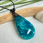 Tropfen Anhänger aus dunklem Maserholz und Epoxidharz in Türkis Blau mit weißer Wellenstruktur am schwarzen Lederband, maritimer Holz Harz Naturschmuck