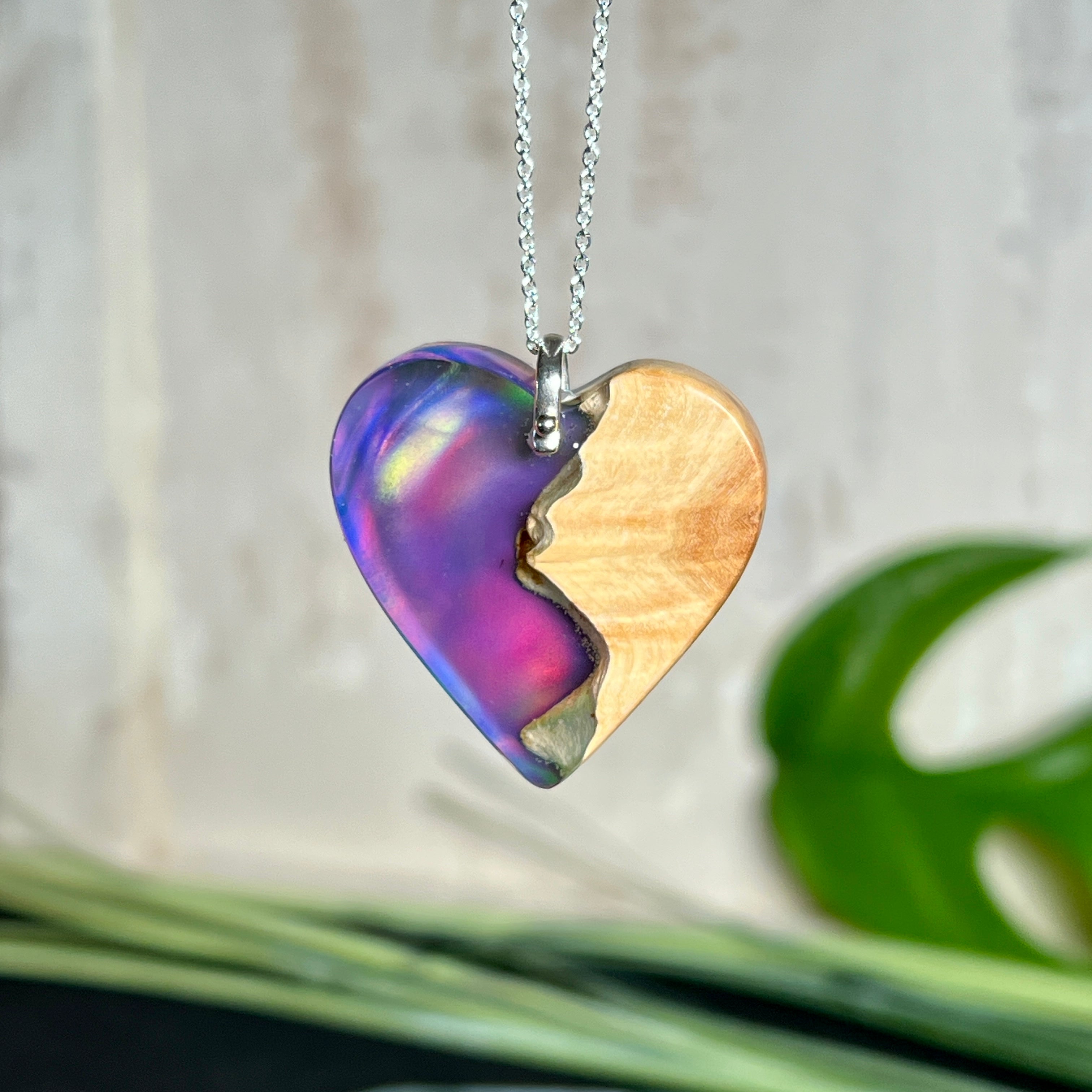Handgefertigter Herzanhänger aus Maserholz und schimmerndem Opalharz, inspiriert von den Farben der Aurora Borealis. Das Holz zeigt eine feine Maserung, das Harz leuchtet in Rosa-, Blau- und Violetttönen. Mit zarter 925 Silber-Ankerkette (1 mm stark, 45 cm lang) und Silberöse. Ein edles Unikat in liebevoller Handarbeit gefertigt.