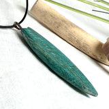 Surfboard Anhänger aus stabilisiertem Holz und Harz in Türkis und Ozeanblau an schwarzer Lederkette, maritimer Holz Harz Naturschmuck unisex