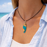 Handgefertigte Surfbrett Kette aus Maserholz und türkisfarbenem Resin mit Edelstahl Anhängerschlaufe an schwarzer Lederkette mit Karabiner und Verlängerung. Filigraner Ocean Anhänger inspiriert von Meer und Wellen, natürlicher Unikat Schmuck für Damen und Herren.