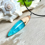 Anhänger aus Eibenholz und Epoxidharz in Blau-Türkis, Weiß und Transparent. Größe ca. 5,8 × 2 cm, Edelstahlöse, Lederkette 45+5 cm. Handgefertigtes Unikat inspiriert vom Ozean.