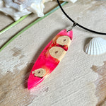 Handgefertigter Surfbrett-Anhänger „Flame Surf“ aus Maserholz und fluoreszierendem Harz in kräftigem Pink. Das Schmuckstück leuchtet bei Schwarzlicht und wird an einer schwarzen Lederkette mit Edelstahl-Karabiner (45 cm + 5 cm Verlängerung) geliefert. Größe ca. 6,7 × 2 cm. Ein Unikat für Surf- und Strandliebhaber, edel verarbeitet und mit Liebe gefertigt.