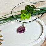 Runder Pusteblumen-Anhänger aus Harz, Hintergrund Brombeerfarben. Durchmesser 22 mm, Edelstahlöse, Lederkette verstellbar mit Edelstahlverschluss.