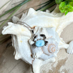 Krabben-Anhänger „Crab of Light“ aus rhodiniertem 925 Sterling Silber mit seltenem Larimar Edelstein aus der Dominikanischen Republik. Der Anhänger (28 × 18 mm) wird mit einer feinen 45 cm langen Silberkette geliefert. Symbol für Schutz, Intuition und die Kraft des Meeres – jedes Schmuckstück ein Unikat durch das natürliche Farbspiel des Larimars.