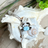Krabben-Anhänger „Crab of Light“ aus rhodiniertem 925 Sterling Silber mit seltenem Larimar Edelstein aus der Dominikanischen Republik. Der Anhänger (28 × 18 mm) wird mit einer feinen 45 cm langen Silberkette geliefert. Symbol für Schutz, Intuition und die Kraft des Meeres – jedes Schmuckstück ein Unikat durch das natürliche Farbspiel des Larimars.