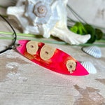 Handgefertigter Surfbrett-Anhänger „Flame Surf“ aus Maserholz und fluoreszierendem Harz in kräftigem Pink. Das Schmuckstück leuchtet bei Schwarzlicht und wird an einer schwarzen Lederkette mit Edelstahl-Karabiner (45 cm + 5 cm Verlängerung) geliefert. Größe ca. 6,7 × 2 cm. Ein Unikat für Surf- und Strandliebhaber, edel verarbeitet und mit Liebe gefertigt.
