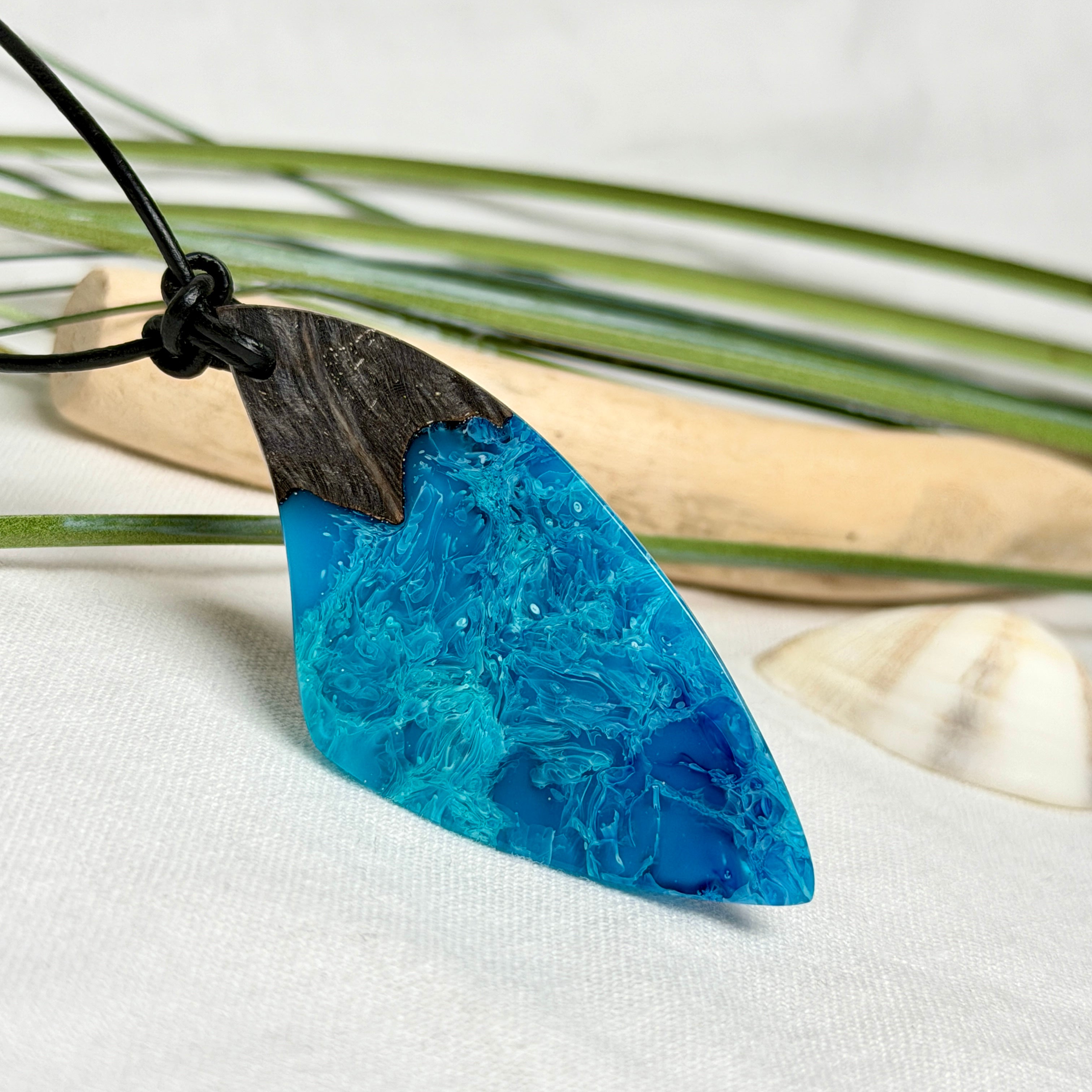 Anhänger aus dunklem Maserholz und Epoxidharz in Blau Türkis mit weißer Wellenstruktur am schwarzen Lederband, maritimer Holz Harz Naturschmuck unisex