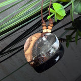 Herzanhänger „Pusteblumenzauber“ aus naturbelassenem Rebholz und klarem Epoxidharz mit schwebenden Pusteblumensamen. Dunkelbraunes, verstellbares Lederband mit kleinen Holzperlen, Anhänger ca. 3,5 × 3,5 cm. Handgefertigtes Unikat von ZeitlosSchmuckDesign.