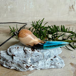 Handgefertigter Anhänger aus Edelholz und transparent-türkisblauem Epoxidharz, glatt poliert. Größe ca. 6,7 × 2,0 cm. Mit Edelstahlöse an schwarzer Lederkette (45 cm + 5 cm Edelstahl-Verlängerung, Karabiner). Maritimer, moderner Unisex-Schmuck mit natürlicher Holzmaserung; kleine Lufteinschlüsse sind charakteristisch.