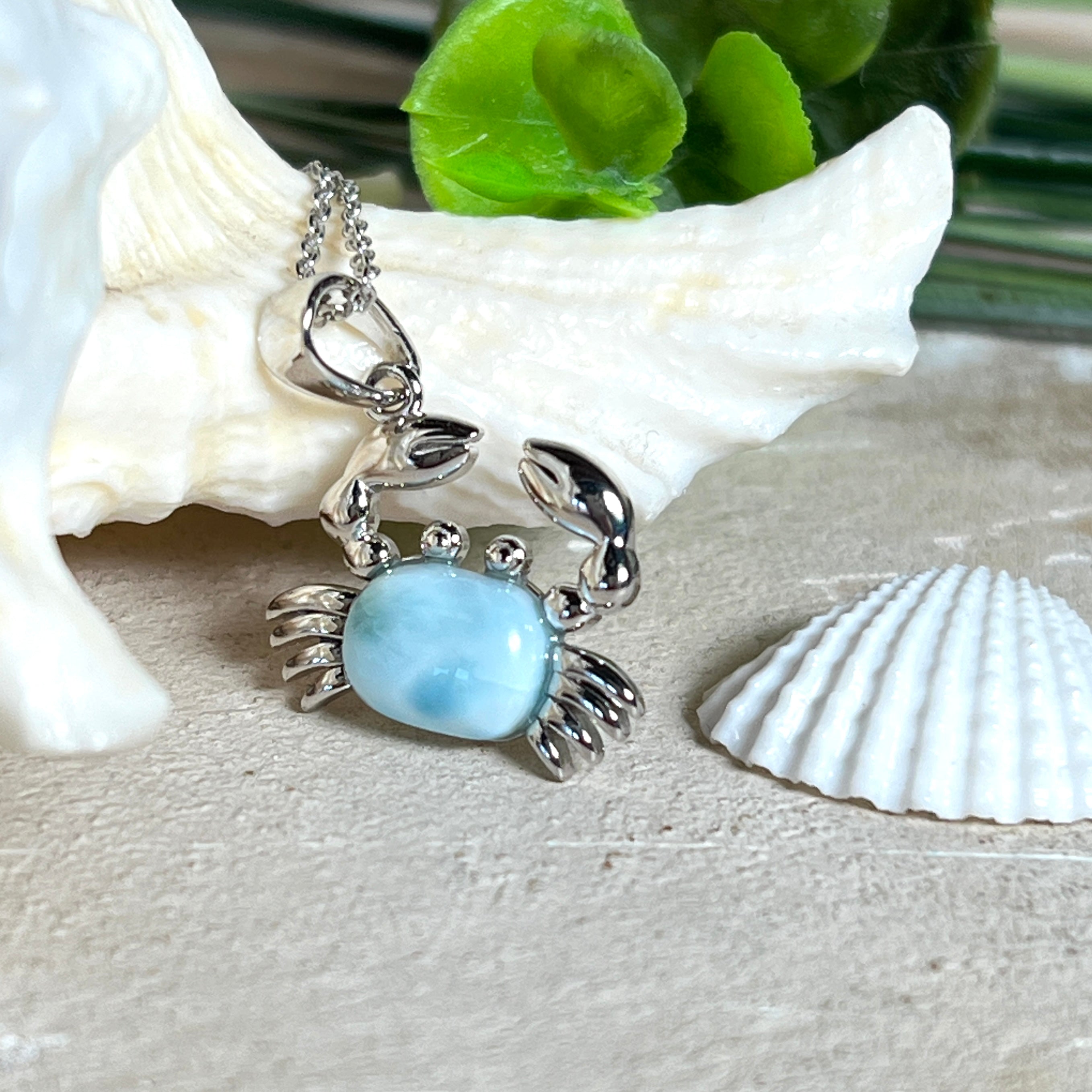 Krabben-Anhänger „Crab of Light“ aus rhodiniertem 925 Sterling Silber mit seltenem Larimar Edelstein aus der Dominikanischen Republik. Der Anhänger (28 × 18 mm) wird mit einer feinen 45 cm langen Silberkette geliefert. Symbol für Schutz, Intuition und die Kraft des Meeres – jedes Schmuckstück ein Unikat durch das natürliche Farbspiel des Larimars.