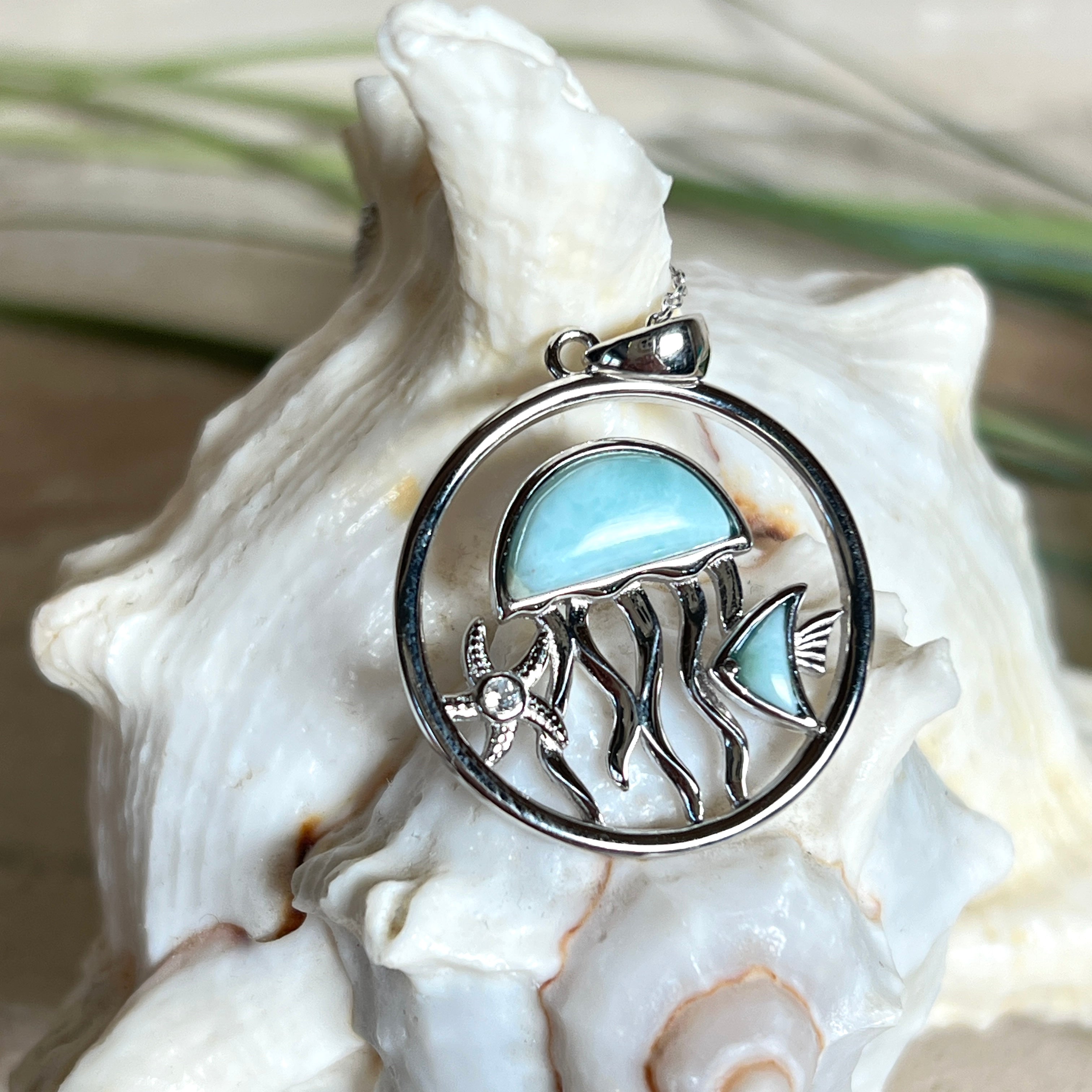 „Sealife“ – runder Anhänger aus rhodiniertem 925 Sterling Silber mit seltenem Larimar und funkelndem Topas. Das maritime Design zeigt eine Qualle, einen Fisch und einen Seestern. Anhängergröße ca. 32 × 26 mm, inklusive 45 cm langer Silberkette (1 mm Stärke). Symbol für die Schönheit und Vielfalt des Ozeans – jedes Stück ein Unikat durch das natürliche Farbspiel des Larimars.