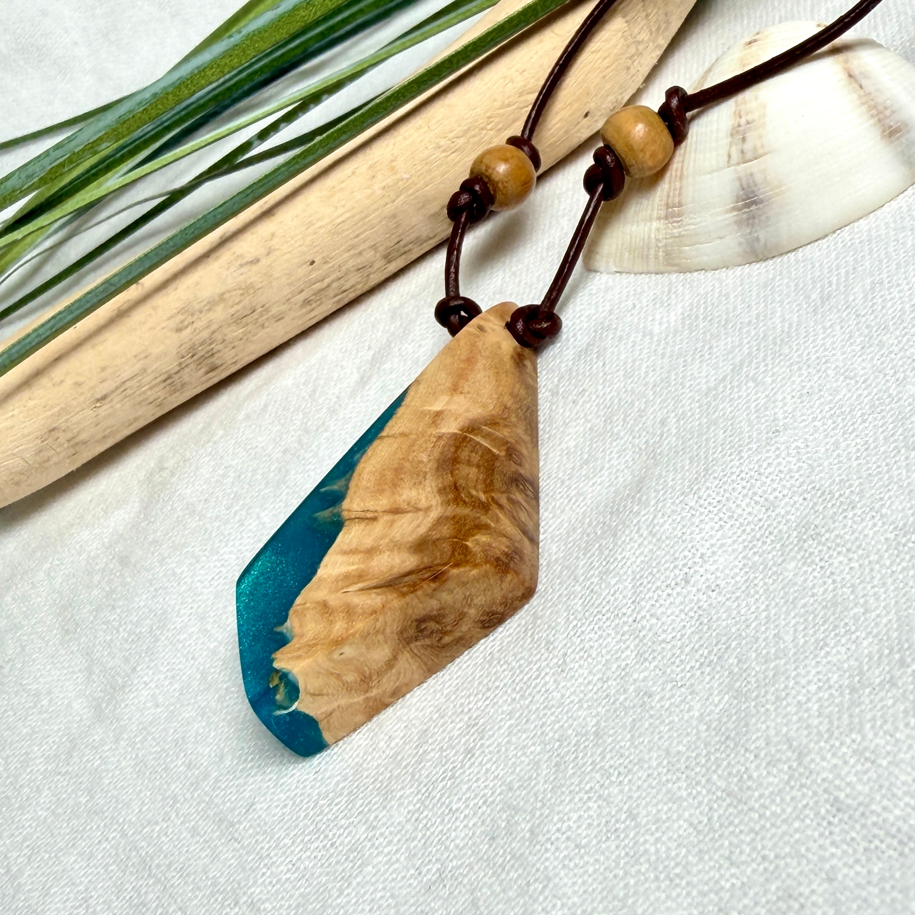 Anhänger aus hellem Goldfield Maserholz (Eukalyptus) und türkis metallischem Epoxidharz am braunen Lederband mit Holzperlen, maritimer Holz Harz Naturschmuck