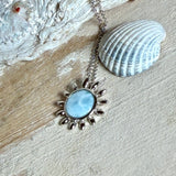 Feine Halskette aus rhodiniertem 925 Silber mit Sonnen-Anhänger und rundem Larimar-Cabochon, 10 mm. Der seltene, hellblaue Stein aus der Dominikanischen Republik erinnert an Meer und Himmel. Gesamtgröße des Anhängers ca. 20 x 19 mm, Ankerkette 45 cm, ca. 1 mm stark. Edler, maritimer Schmuck, geliefert in einer Geschenkbox.