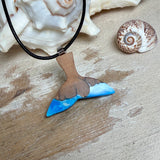 Handgefertigter Walflossen-Anhänger aus Olivenholz und Epoxidharz in Blau-Grün-Weiß, polierte Oberfläche, Edelstahl-Öse. Schwarze Lederkette 45 cm mit Edelstahl-Karabinerverschluss und 5 cm Edelstahl-Verlängerung. Anhängergröße ca. 2,5 × 3,2 cm, maritime Produktfotografie.