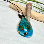 Holz-Harz-Anhänger aus Maserholz mit türkis-blauem Epoxidharz in Tropfenform am verstellbaren Lederband mit Onyxperlen, handgemachter maritimer Naturschmuck