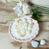 Handgefertigte Kerze „Meeresträume“ in einer Jesmonite-Schale (ca. 11 cm). Gefüllt mit nachhaltigem Sojawachs, verziert mit echten Muscheln, handgegossenen Wachsmuscheln und Seepferdchen. Feiner Glitzer sorgt für funkelnde Lichteffekte im Kerzenschein. Maritime Deko – edel, einzigartig & perfekt als Geschenk.