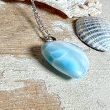 Larimar-Herzanhänger in zarten Blau- und Weißtönen, beidseitig poliert, an einer feinen platinrhodinierten 925 Silber Ankerkette mit 1 mm Stärke und 45 cm Länge. Das seltene Larimar-Herz aus der Dominikanischen Republik erinnert optisch an Meer und Himmel .