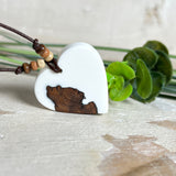 Herzanhänger „Pure Heart“ aus Maserholz und weißem Epoxidharz. Handgefertigtes Unikat mit kontrastreichem Design – die natürliche Maserung des Holzes trifft auf die klare Reinheit von Weiß. Größe ca. 3,5 × 3,5 cm. Verstellbares Lederband (23–41 cm) mit Holzperlen. Ein edles Schmuckstück, inspiriert von Natur und Liebe.