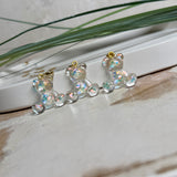 Kleiner Bärchen-Anhänger aus transparentem Harz mit irisierenden Flakes in Regenbogen-Schimmer, goldfarbene Anhängerschlaufe aus Edelstahl. Größe ca. 2,2 × 2,1 cm. Handgefertigtes Unikat; Flakes-Anordnung variiert, vereinzelt kleine Luftbläschen möglich.