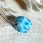 Feine Kette mit rundem Larimar-Cabochon in AA-Qualität. Der ca. 20 mm große Stein zeigt ein intensives Blau mit hellen, netzartigen Zeichnungen und ist mittig mit einer 2,5 mm Bohrung versehen, durch die eine zarte 925 Silberkette (45 cm, ca. 1 mm stark) geführt wird. 