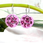 Handgemachte Leo-Creolen aus 925 Silber: Silber-Creolen 16 mm mit rosa Harz-Scheibe (2 cm) im Leoparden-Look und Edelstahl-Herzanhänger. Hängende Ohrringe in Animal-Print Stil, Gesamtlänge ca. 3,5 cm. Resin-Ohrringe für Alltag, Party oder Festival, femininer Statement-Schmuck in Rosa/Pink mit silberfarbenen Metallteilen. Einzeln gegossen, jedes Paar ein Unikat; leichte Abweichungen im Muster, Farbspiel und kleine Luftbläschen sind möglich und typisch für Handarbeit.