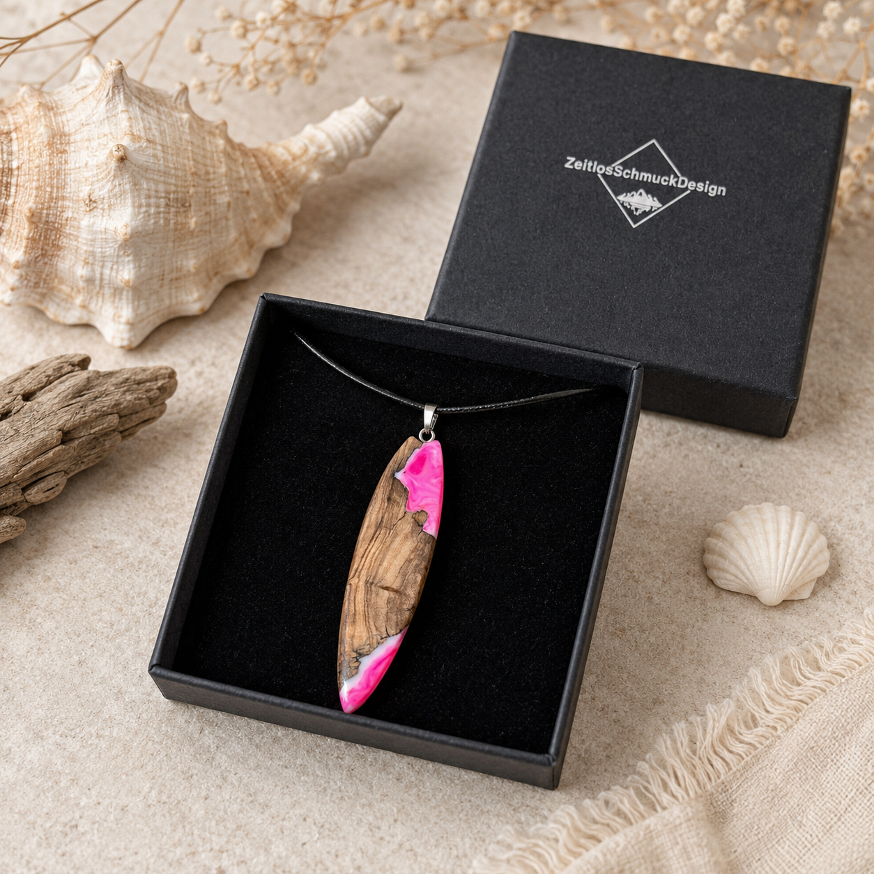 Pink Glow Surfbrett Anhänger aus Olivenholz und fluoreszierendem Epoxidharz in Pink-Weiß, handgefertigte Lederkette in schwarzer Schmuckbox von ZeitlosSchmuckDesign, maritimer Schmuck für Damen mit UV-Schwarzlicht-Effekt.