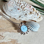 Feine Halskette aus rhodiniertem 925 Silber mit Sonnen-Anhänger und rundem Larimar-Cabochon, 10 mm. Der seltene, hellblaue Stein aus der Dominikanischen Republik erinnert an Meer und Himmel. Gesamtgröße des Anhängers ca. 20 x 19 mm, Ankerkette 45 cm, ca. 1 mm stark. Edler, maritimer Schmuck, geliefert in einer Geschenkbox.