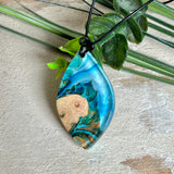 Handgefertigter Anhänger „Ocean Leaf“ aus Maserholz und Epoxidharz in Blau- und Türkistönen. Ein einzigartiges Schmuckstück, das die Schönheit von Natur und Meer einfängt. Mit verstellbarem Lederband (24–43 cm). Jeder Anhänger ist ein Unikat mit einzigartiger Maserung und Farbverlauf.