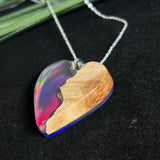 Handgefertigter Herzanhänger aus Maserholz und schimmerndem Opalharz, inspiriert von den Farben der Aurora Borealis. Das Holz zeigt eine feine Maserung, das Harz leuchtet in Rosa-, Blau- und Violetttönen. Mit zarter 925 Silber-Ankerkette (1 mm stark, 45 cm lang) und Silberöse. Ein edles Unikat in liebevoller Handarbeit gefertigt.