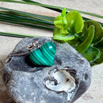 Halskette mit Malachit-Herz: kleiner, gewölbter Herzanhänger aus intensiv grün gebändertem Malachit, ca. 16 x 14 x 10 mm, in hochglanzpolierter, rhodinierter 925 Silberfassung an feiner Ankerkette aus Silber.