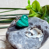 Halskette mit Malachit-Herz: kleiner, gewölbter Herzanhänger aus intensiv grün gebändertem Malachit, ca. 16 x 14 x 10 mm, in hochglanzpolierter, rhodinierter 925 Silberfassung an feiner Ankerkette aus Silber.