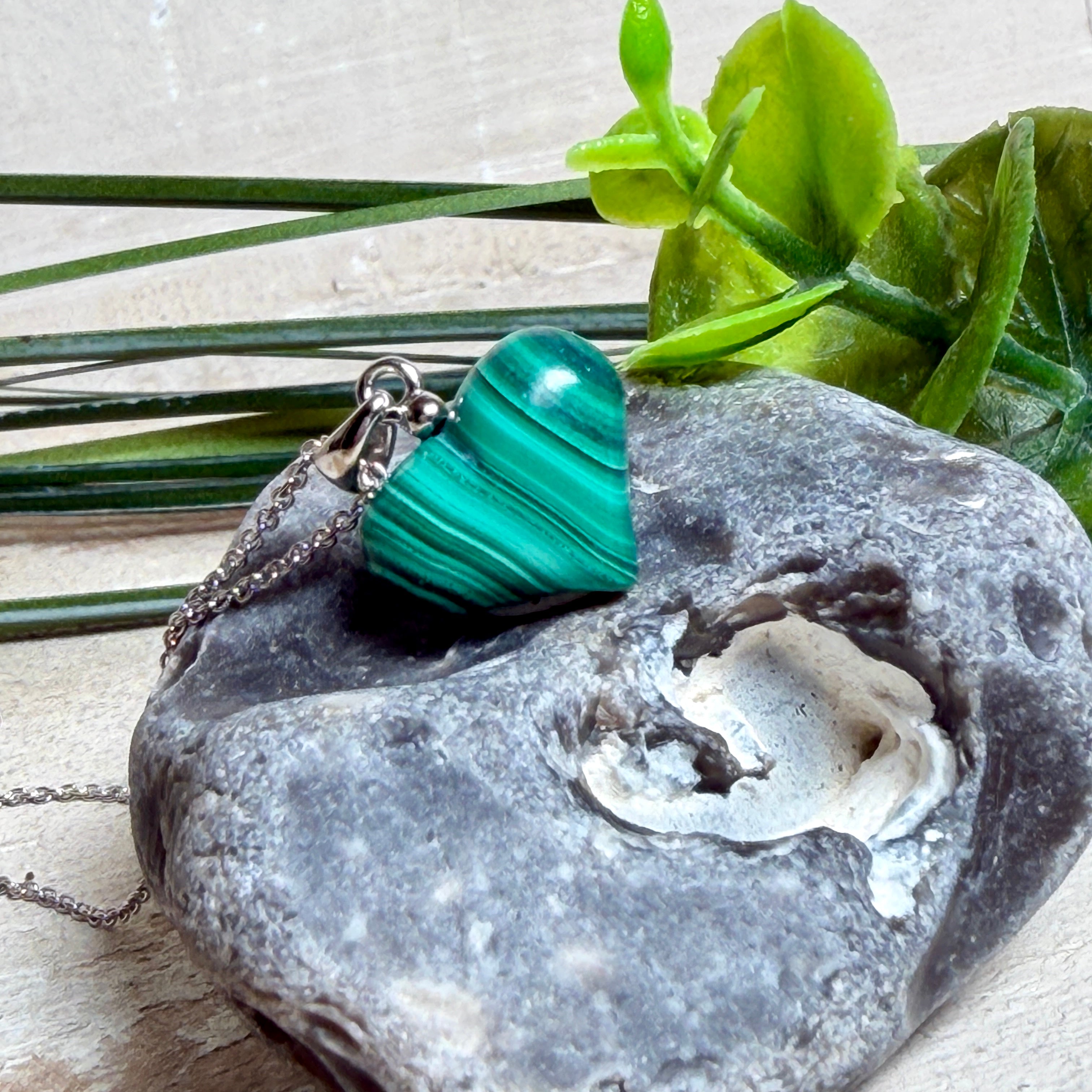 Halskette mit Malachit-Herz: kleiner, gewölbter Herzanhänger aus intensiv grün gebändertem Malachit, ca. 16 x 14 x 10 mm, in hochglanzpolierter, rhodinierter 925 Silberfassung an feiner Ankerkette aus Silber.