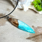 Anhänger aus Eibenholz und Epoxidharz in Blau-Türkis, Weiß und Transparent. Größe ca. 5,8 × 2 cm, Edelstahlöse, Lederkette 45+5 cm. Handgefertigtes Unikat inspiriert vom Ozean.
