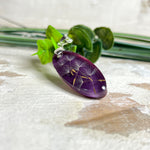 Ovaler Anhänger mit echter Pusteblume in Harz, Hintergrund Brombeerfarben. Größe 4 × 1,8 cm, versilberte Kette 50 cm mit Karabinerverschluss. Handgefertigtes Unikat.