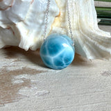 Feine Kette mit rundem Larimar-Cabochon in AA-Qualität. Der ca. 20 mm große Stein zeigt ein intensives Blau mit hellen, netzartigen Zeichnungen und ist mittig mit einer 2,5 mm Bohrung versehen, durch die eine zarte 925 Silberkette (45 cm, ca. 1 mm stark) geführt wird. 
