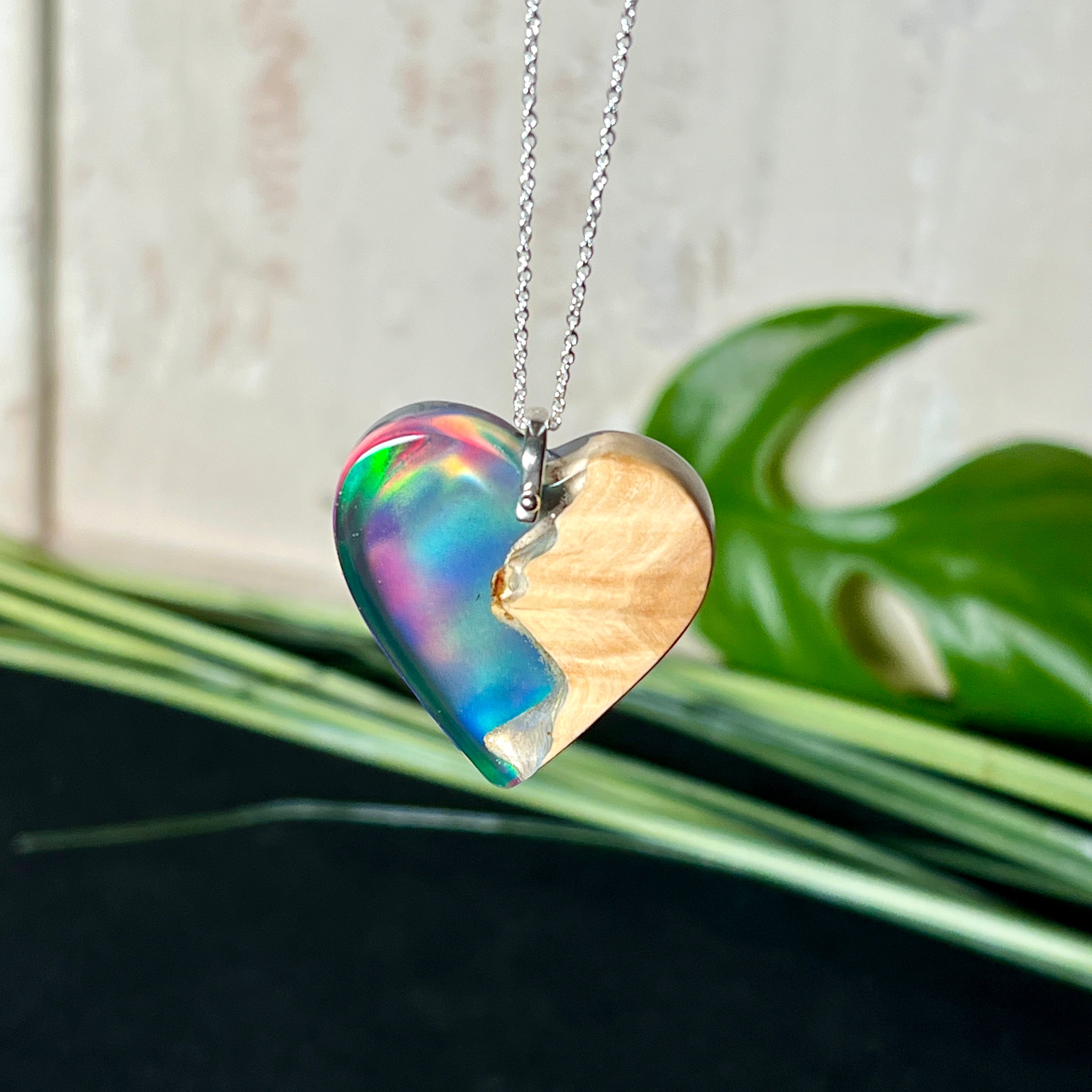 Handgefertigter Herzanhänger aus Maserholz und schimmerndem Opalharz, inspiriert von den Farben der Aurora Borealis. Das Holz zeigt eine feine Maserung, das Harz leuchtet in Rosa-, Blau- und Violetttönen. Mit zarter 925 Silber-Ankerkette (1 mm stark, 45 cm lang) und Silberöse. Ein edles Unikat in liebevoller Handarbeit gefertigt.