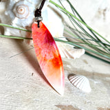 Handgefertigter Surfbrett-Anhänger aus fluoreszierendem Epoxidharz in leuchtenden Orange-, Rot- und Gelbtönen. Leuchtet bei Schwarzlicht. Kombiniert mit verstellbarem Lederband (26–45 cm), verziert mit Spacer- und Holzperlen. Das Design ist inspiriert von der Farbintensität eines Sonnenuntergangs über dem Meer.