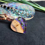 Handgemachter Herzanhänger aus Eibenholz mit lila Harz und Paua-Muschel-Inlay an braunem, verstellbarem Lederband.