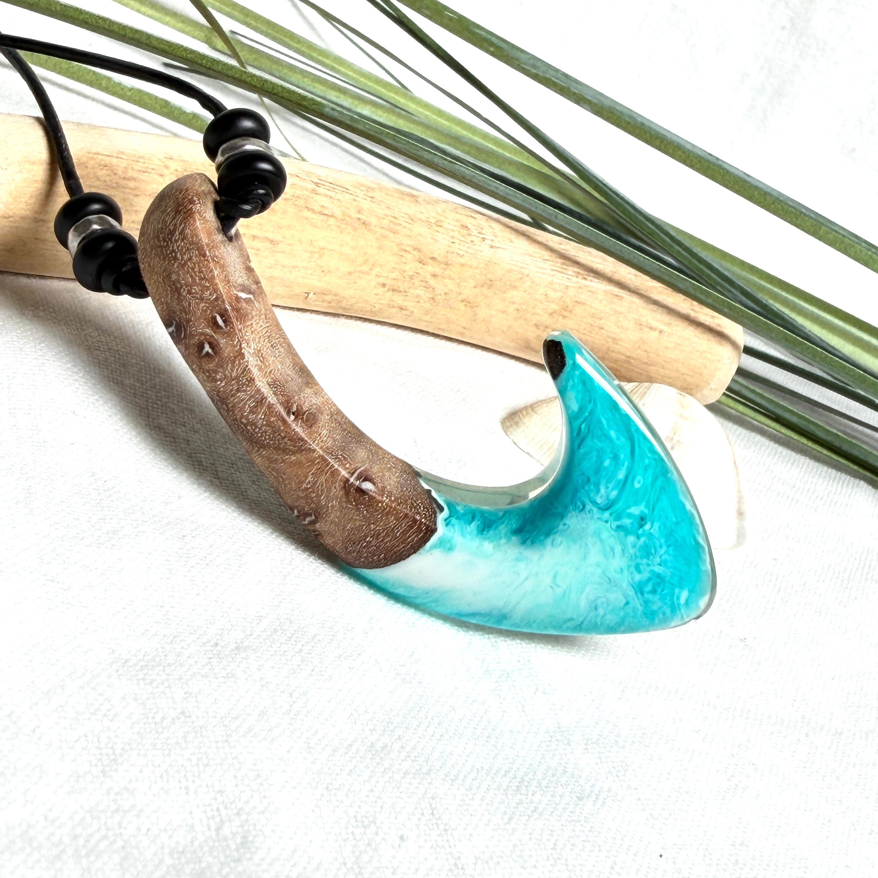 Angelhaken Anhänger aus braunem Maserholz und türkis hellblauem Epoxidharz am schwarzen Lederband mit Onyxperlen, Hei Matau Naturschmuck im Māori Stil