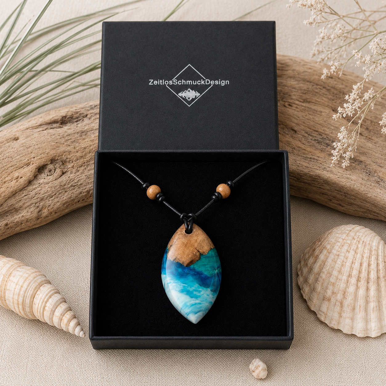 Schmuckbox-Bild BRANDUNG – handgefertigter Holz-Harz-Anhänger aus Maserholz und Epoxidharz in Blau, Türkis und Weiß, maritimer Naturschmuck am verstellbaren Lederband mit Holzperlen, Unikat in schwarzer ZeitlosSchmuckDesign Schmuckbox.