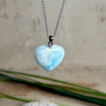 Larimar-Herzanhänger in zarten Blau- und Weißtönen, beidseitig poliert, an einer feinen platinrhodinierten 925 Silber Ankerkette mit 1 mm Stärke und 45 cm Länge. Das seltene Larimar-Herz aus der Dominikanischen Republik erinnert optisch an Meer und Himmel .