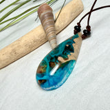 Holz-Harz-Anhänger aus Maserholz mit türkis-blauem Epoxidharz in Tropfenform am verstellbaren Lederband mit Onyxperlen, handgemachter maritimer Naturschmuck